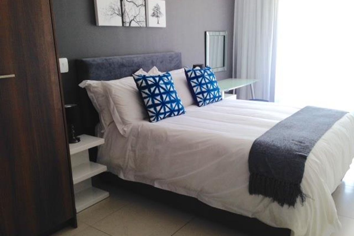 A well-maintained bedroom featuring neutral tiled flooring and a built-in wardrobe, offering a clean and functional living space.