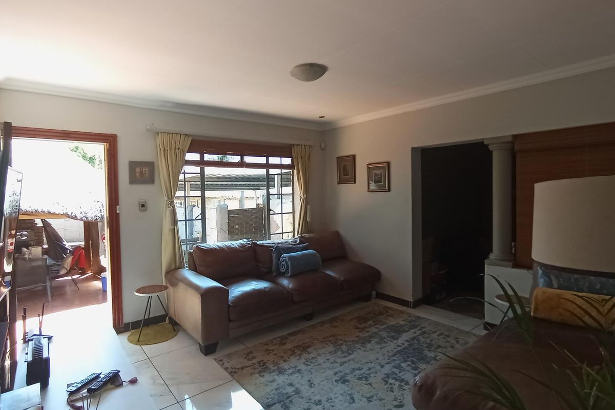 A living room featuring tiled flooring, a coved ceiling, and direct access to an outdoor patio area through a sliding door.