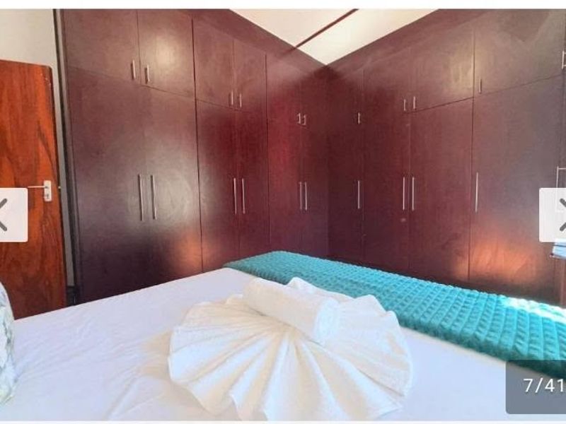 Bedroom featuring extensive dark wood built-in cupboards providing ample storage space.