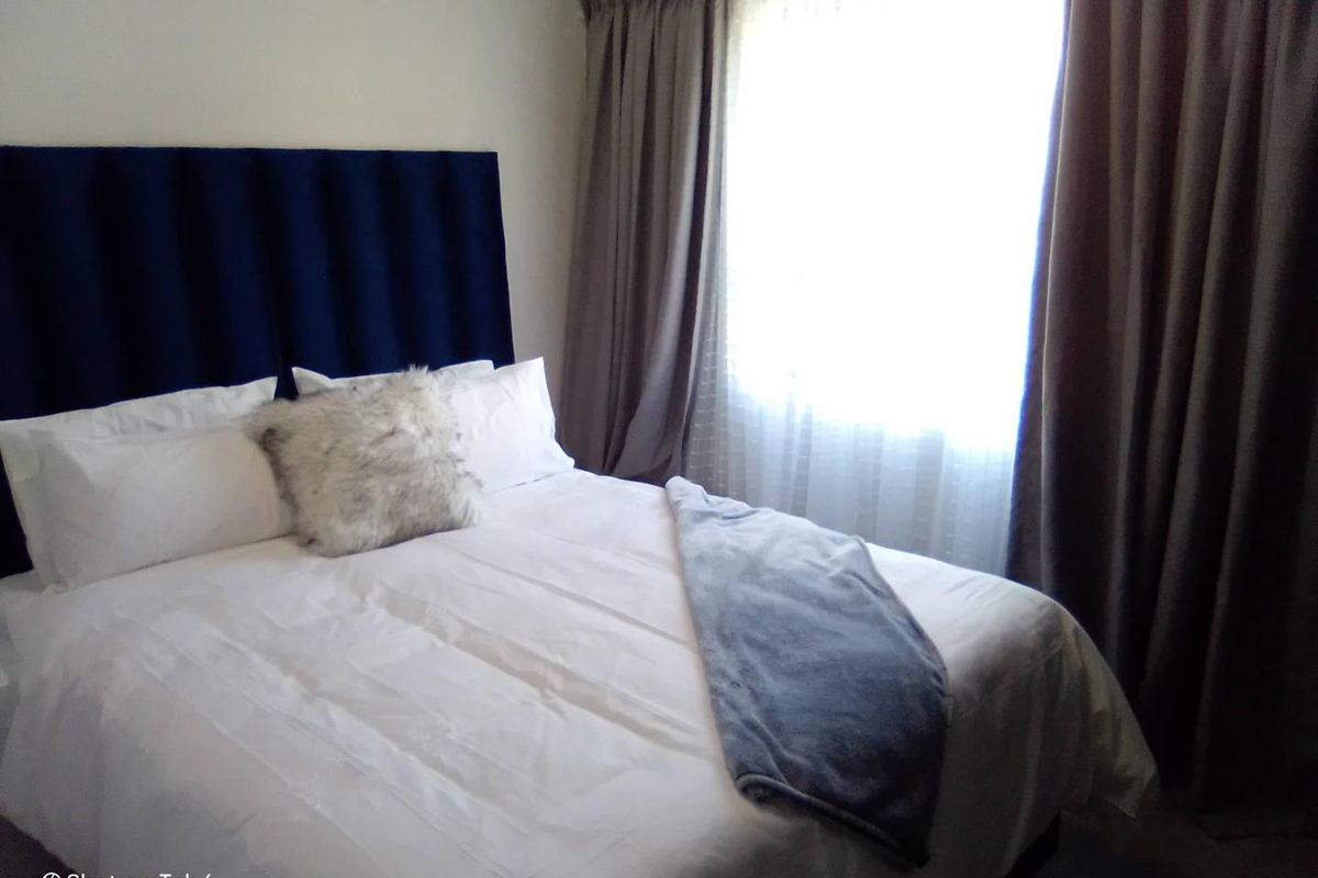 A bedroom featuring a window with curtains, providing natural light to the space.