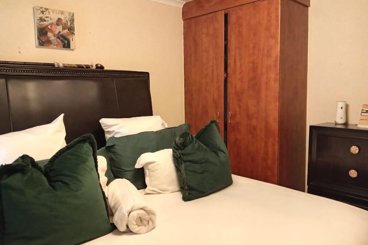 A bedroom featuring a built-in wooden wardrobe and neutral wall finishes.