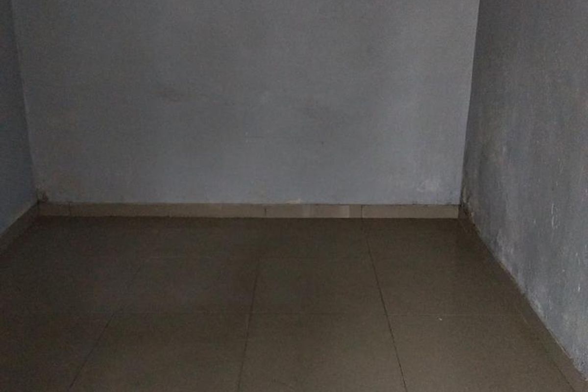 An empty, unfurnished room featuring tiled flooring and plain walls, requiring cosmetic updates to improve its overall condition and appeal.