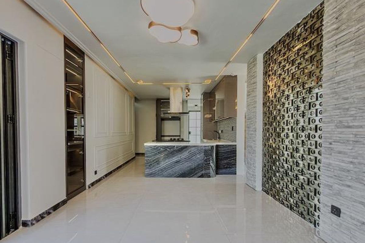 Modern kitchen featuring a striking marble island, integrated cabinetry, and a decorative stone feature wall with recessed ceiling lighting.