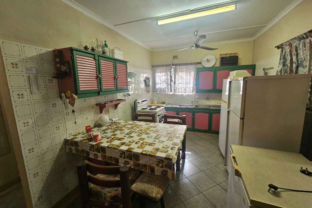 A dated kitchen featuring original cabinetry, tiled splashbacks, and tiled flooring, offering significant potential for a modern renovation.