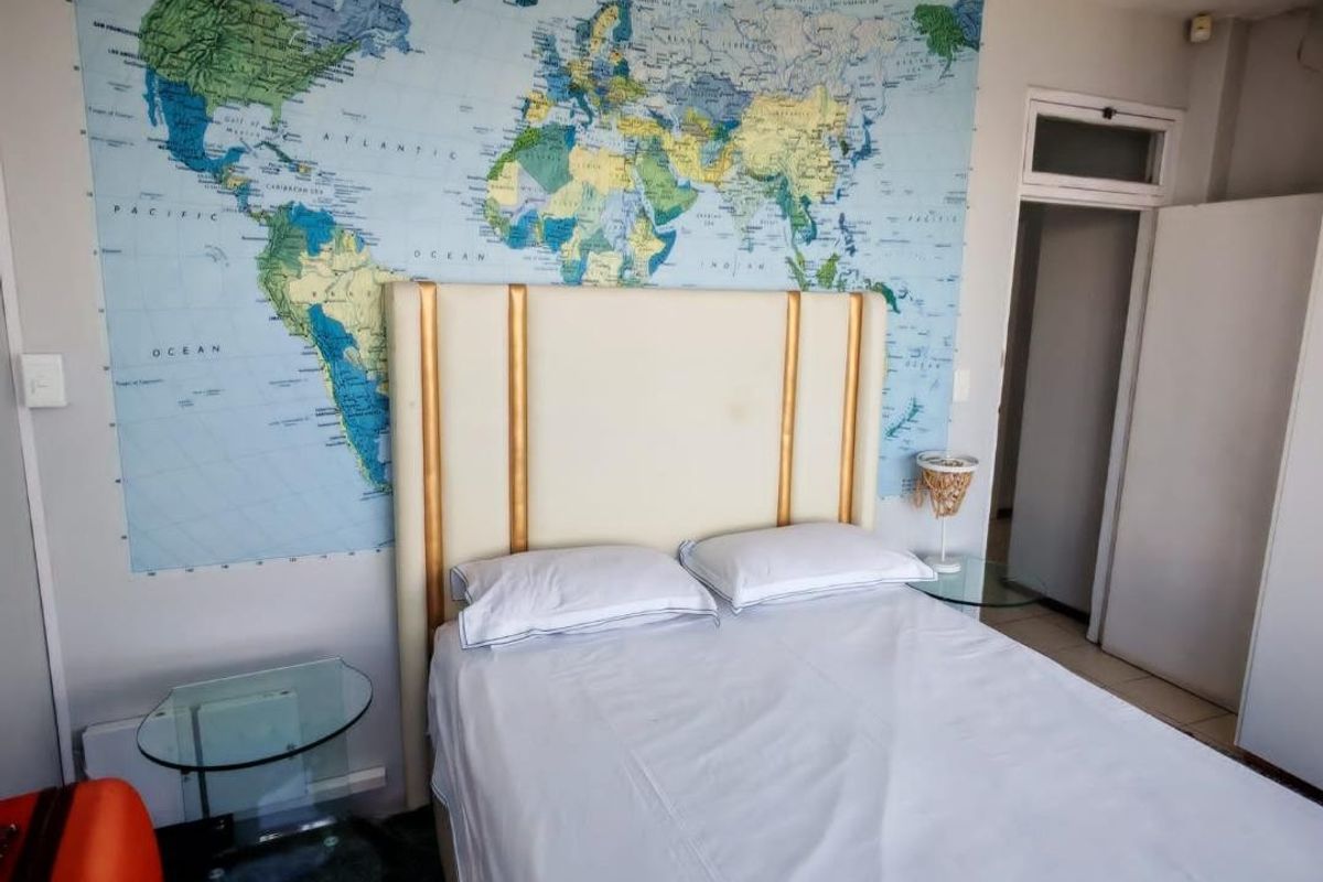 A bedroom featuring a built-in wardrobe and a large wall-mounted world map feature.