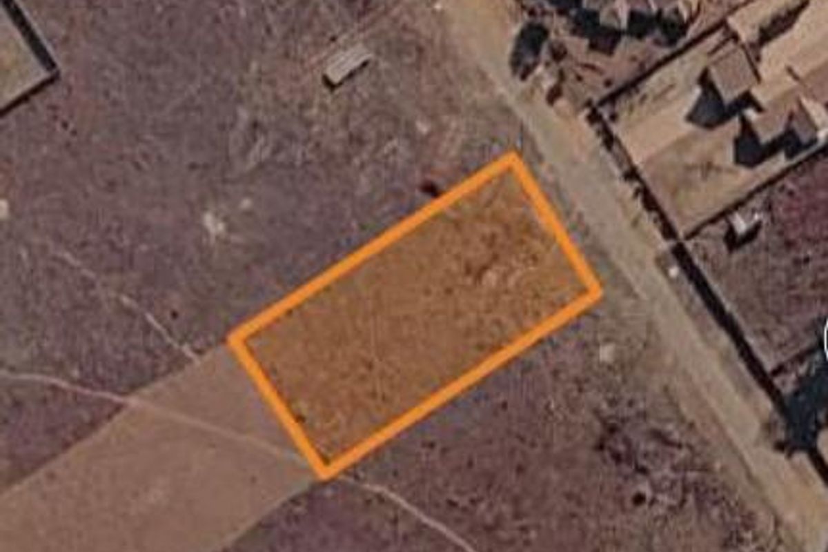An aerial view of a vacant residential plot of land, highlighting the property boundaries in a developing neighborhood.