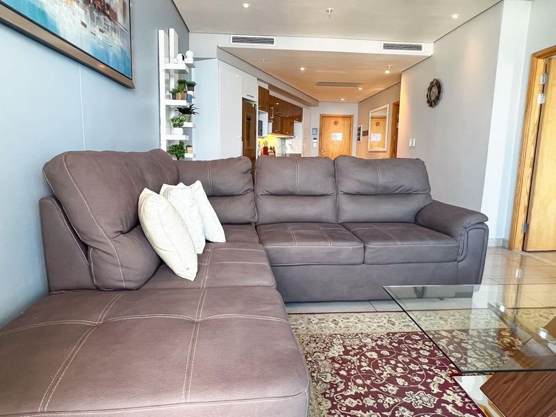 Open-plan living area featuring tiled flooring, recessed lighting, and ducted air conditioning, flowing seamlessly into the adjacent kitchen space.