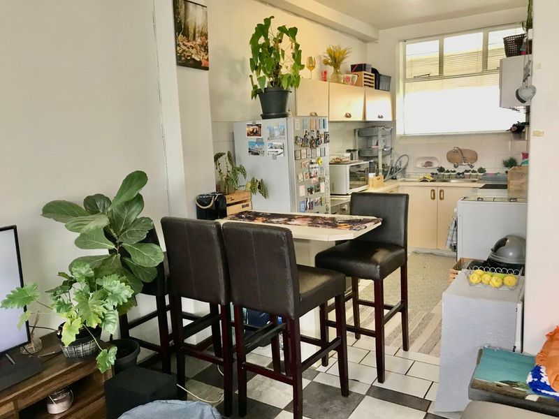 Open plan kitchen and dining area featuring dated cabinetry, tiled flooring, and a functional layout suitable for modernization.
