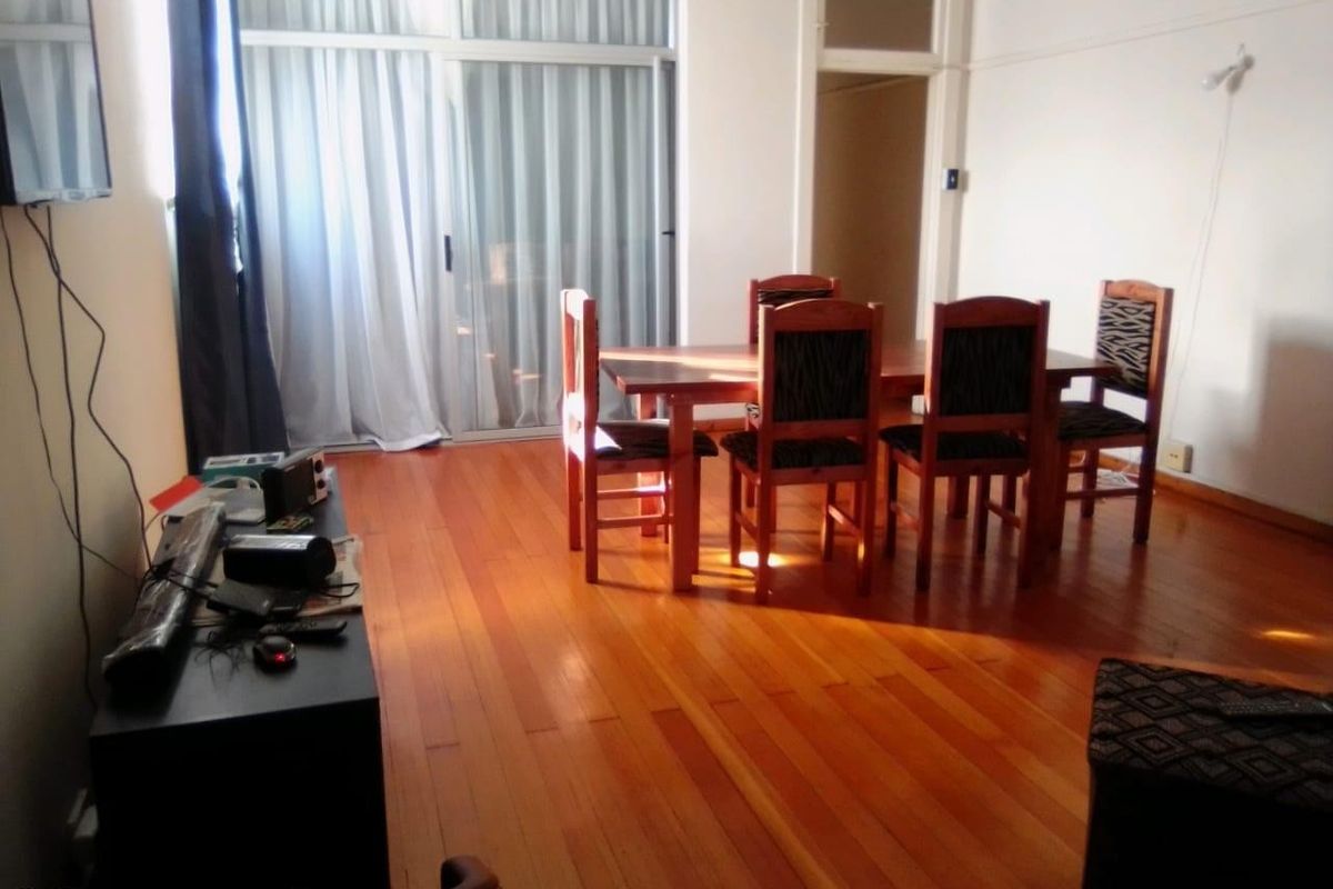 A living and dining area featuring polished hardwood flooring and a large sliding glass door providing access to the exterior.