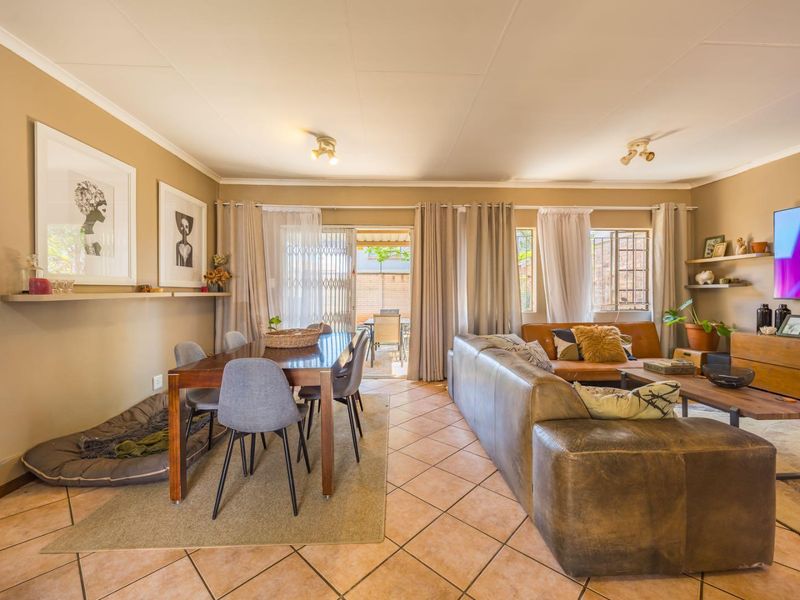 Spacious open-plan living and dining area featuring ceramic tile flooring, neutral wall tones, and direct access to an outdoor patio through sliding glass doors.