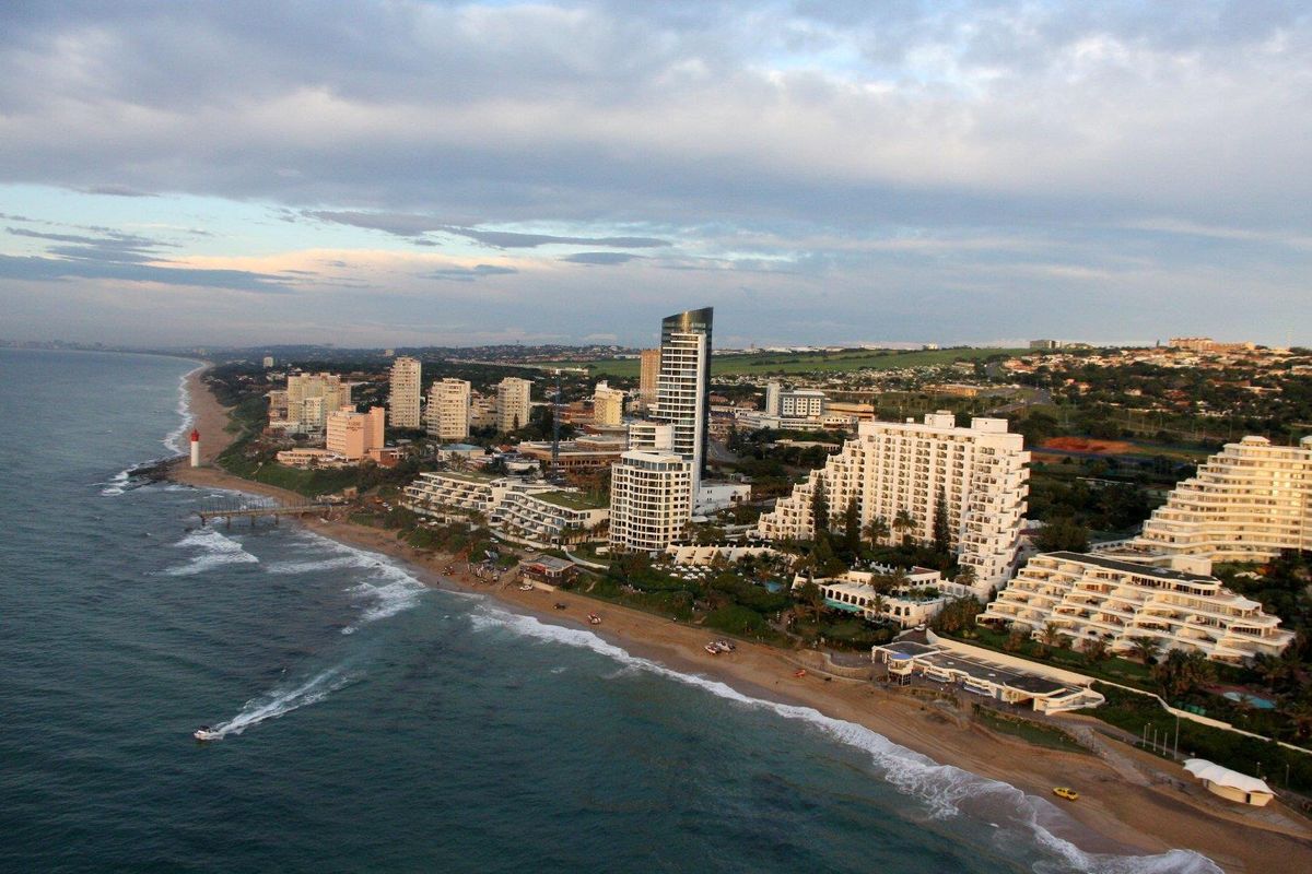 An aerial view of the coastal cityscape, showcasing the beachfront apartment developments and the surrounding urban landscape.