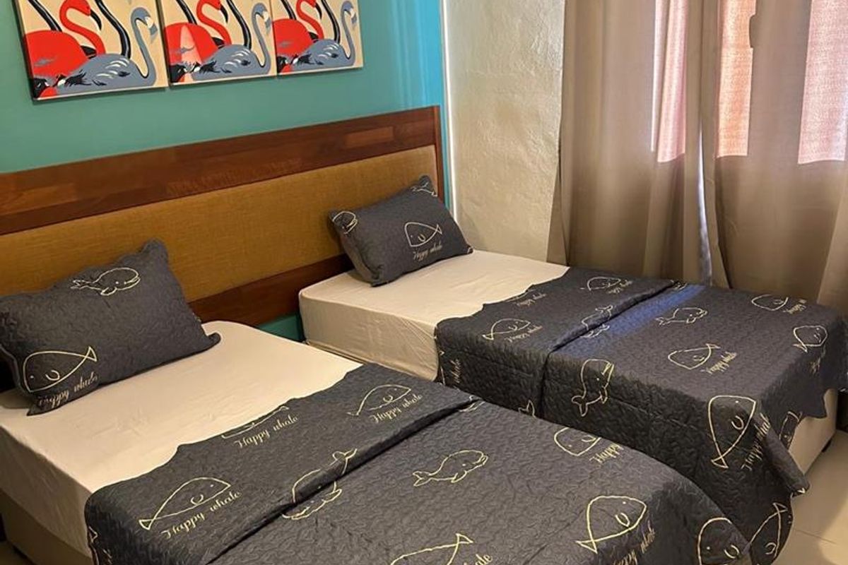 A bedroom featuring a wooden headboard, tiled flooring, and a wall-mounted air conditioning unit.