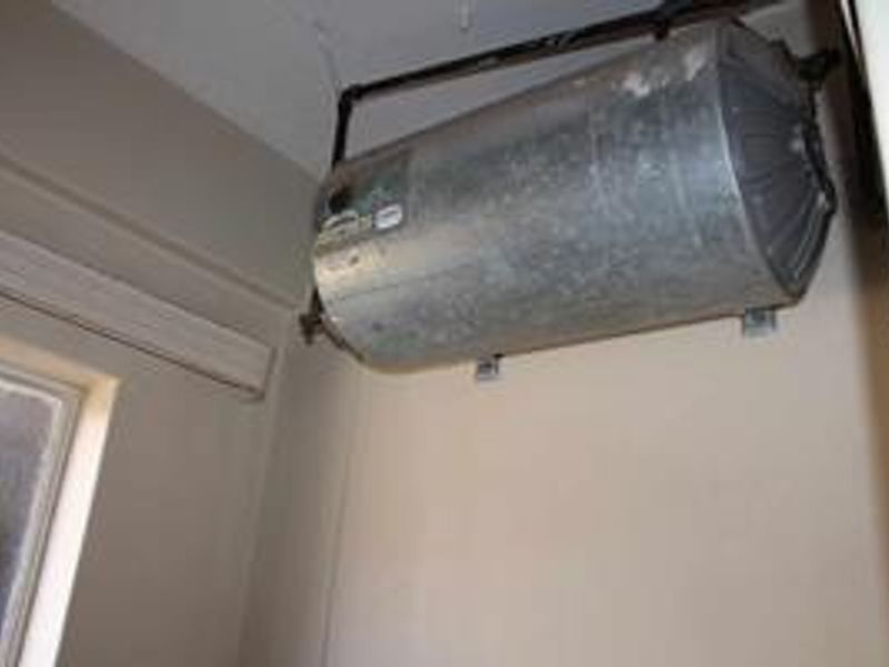 A utility space featuring a wall-mounted electric water heater unit.