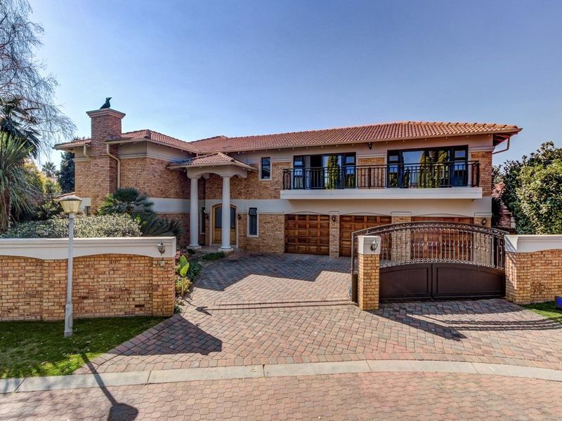 A well-maintained double-story brick residence featuring a triple garage, paved driveway, secure gated entrance, and an upper-level balcony.