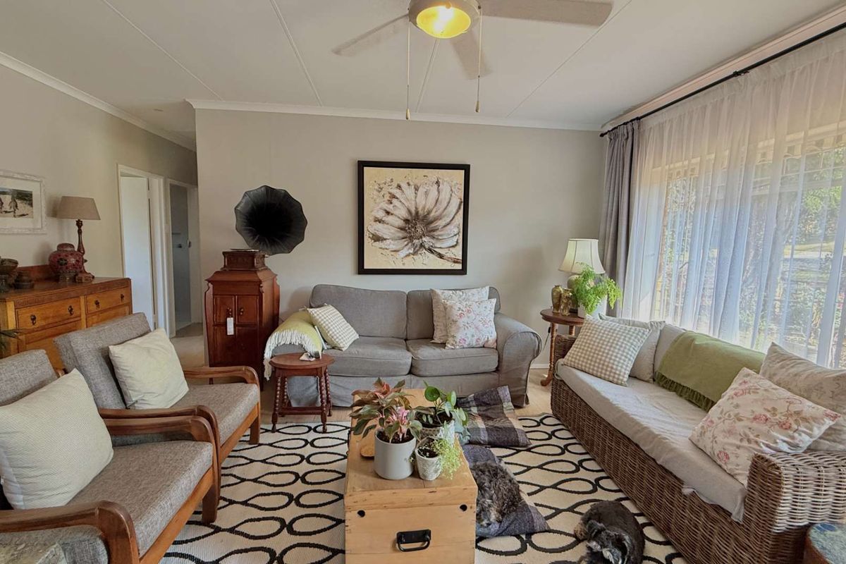 A comfortable living room featuring a ceiling fan and large windows that provide ample natural light.