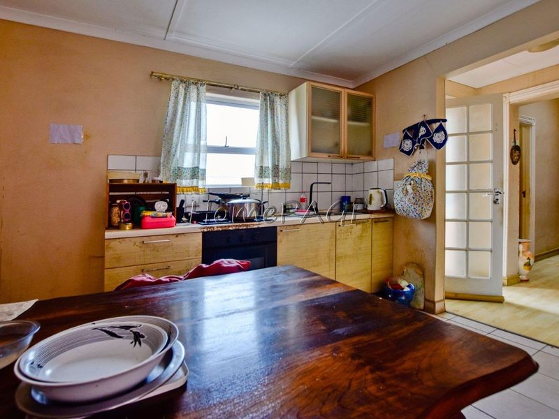 A dated kitchen featuring built-in cabinetry, a tiled backsplash, and an integrated oven, offering potential for modernization and cosmetic updates.