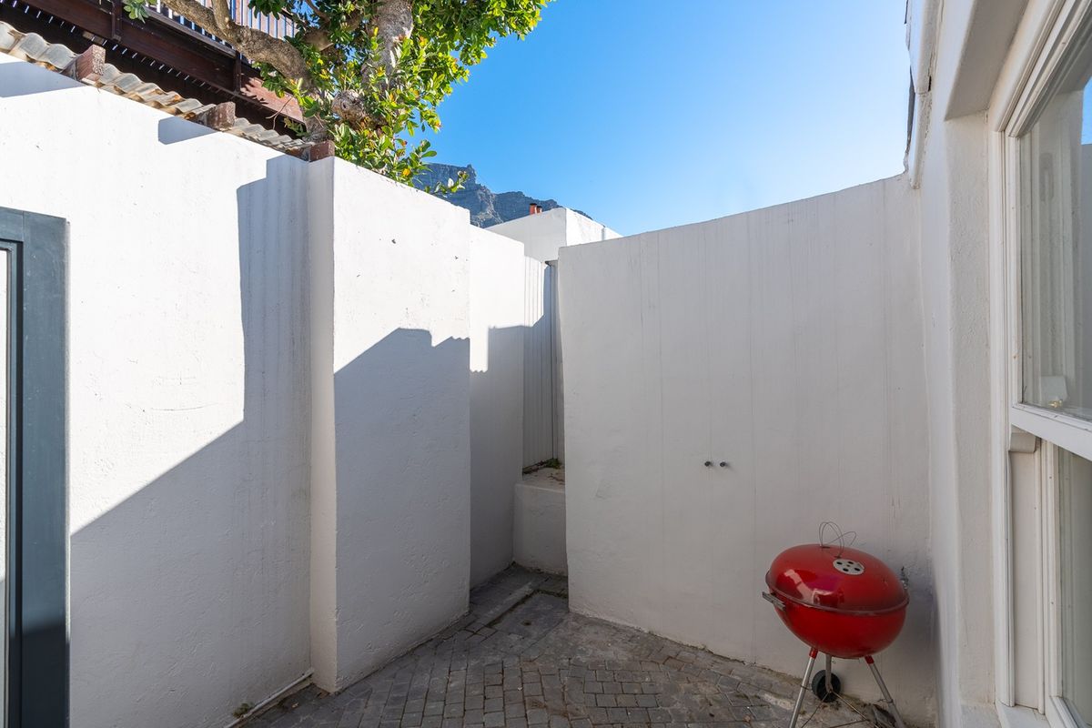 A private rear courtyard area featuring paved flooring and high boundary walls, offering a secluded outdoor space.