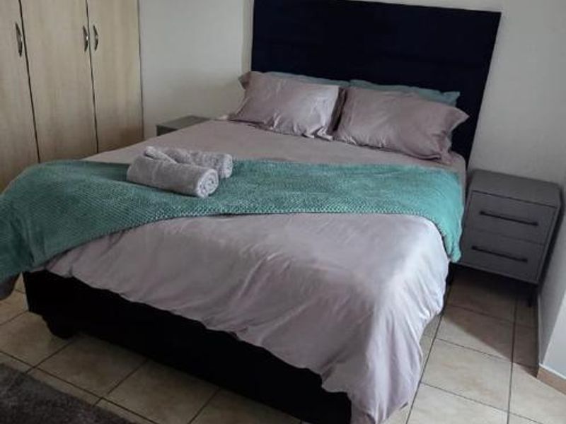 A bedroom featuring tiled flooring and built-in cupboards, providing functional storage space.