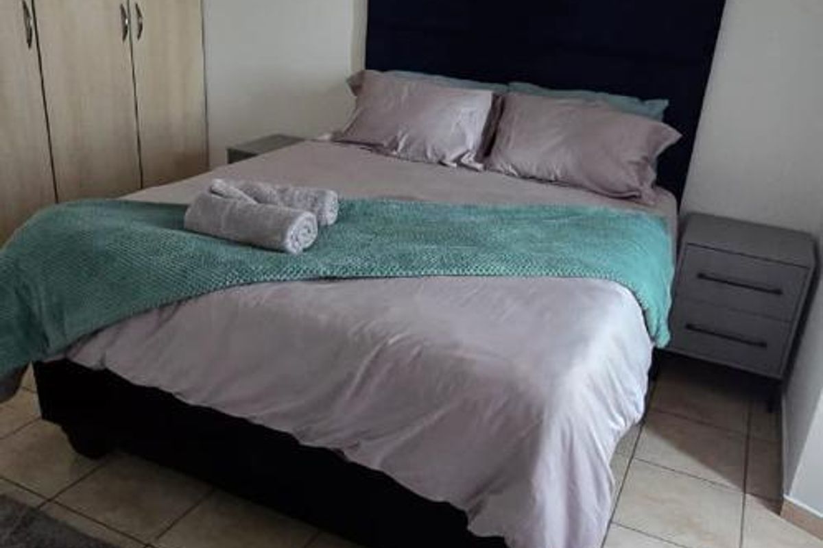 A bedroom featuring tiled flooring and built-in cupboards, providing functional storage space.