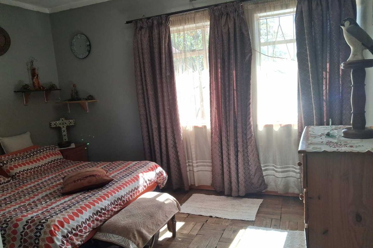 A bedroom featuring original parquet flooring, large windows with curtain treatments, and a ceiling ventilation unit.
