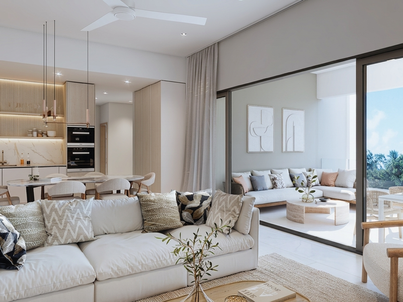Modern open-plan living area featuring a sleek kitchen with integrated appliances, stone finishes, and seamless flow to a spacious covered balcony.