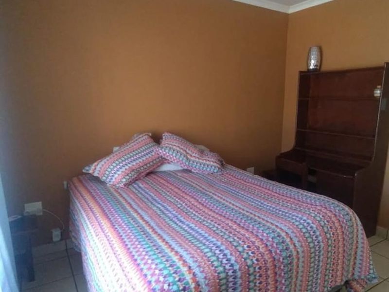 A bedroom featuring tiled flooring and neutral wall finishes, providing a functional space for rest.