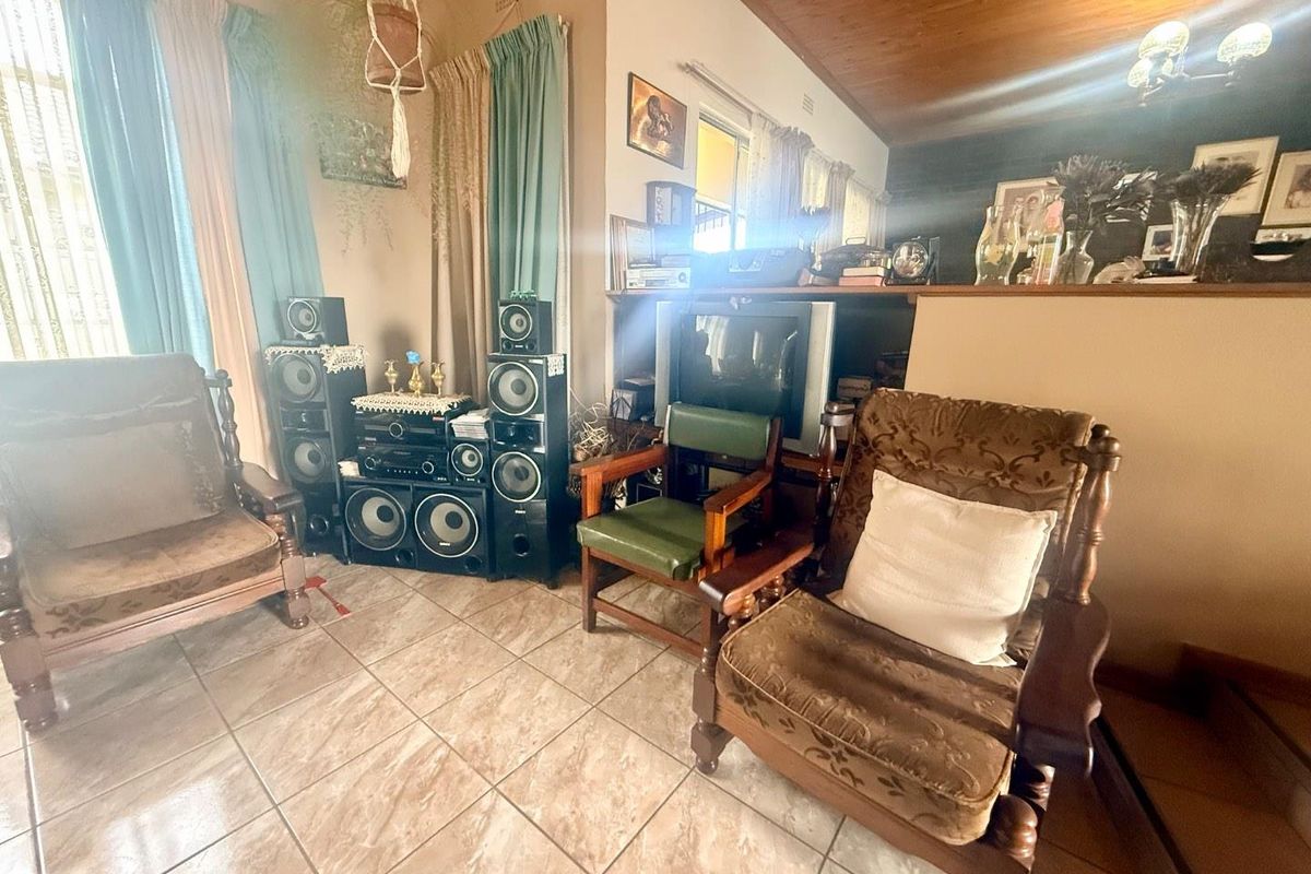 A living room featuring tiled flooring and a timber-paneled ceiling, offering a cozy space for relaxation.
