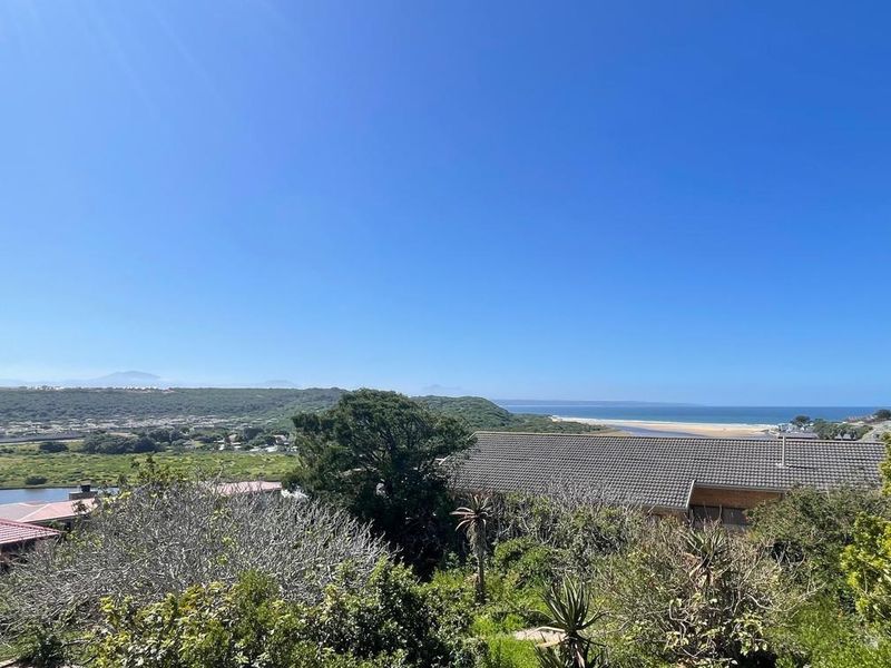 A scenic elevated view overlooking the coastal landscape, estuary, and distant beach, showcasing the natural surroundings of the property.