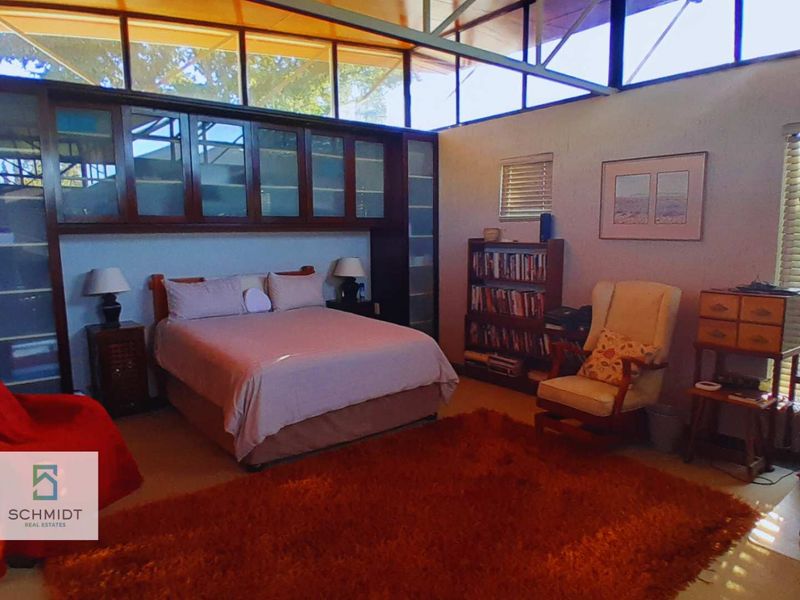 Spacious bedroom featuring extensive built-in cabinetry and high clerestory windows that provide ample natural light.