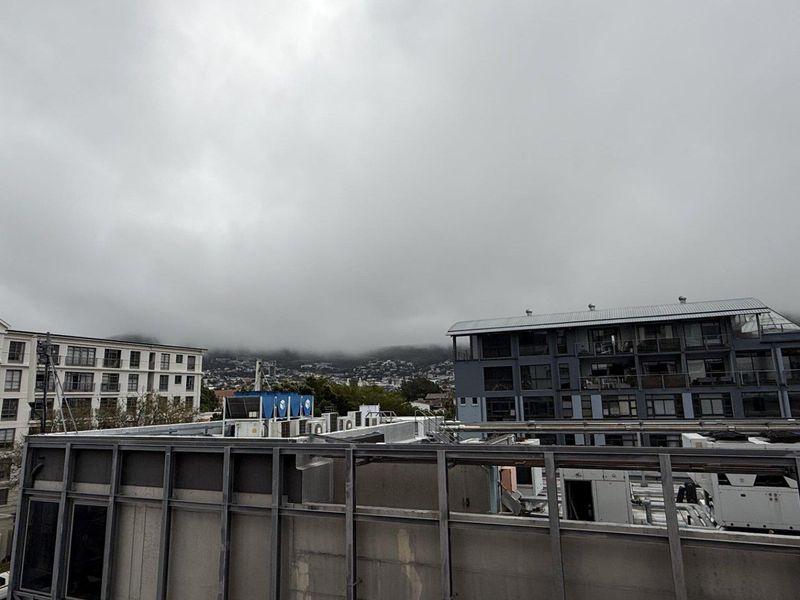 An elevated view overlooking surrounding office buildings and urban infrastructure under a cloudy sky.