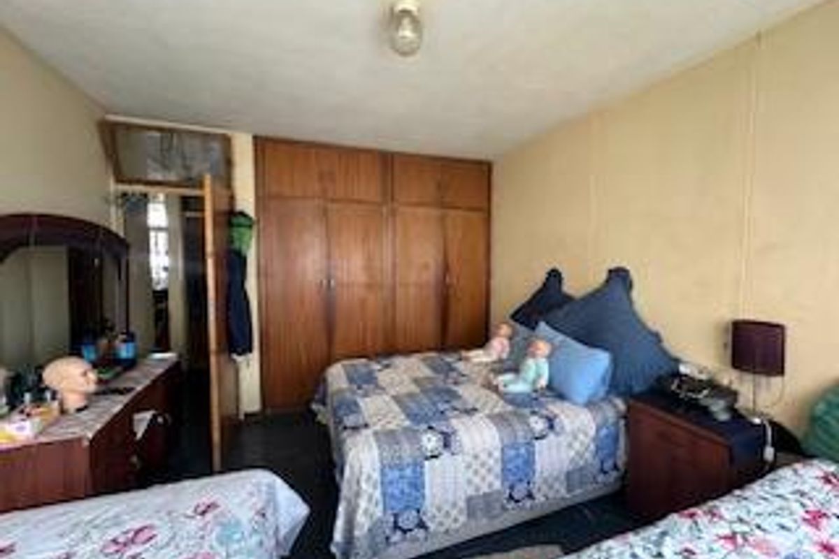 A bedroom featuring built-in wooden wardrobes, providing ample storage space within a functional layout.