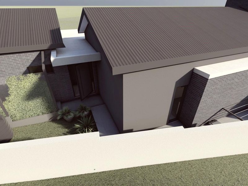 An aerial perspective of a modern residential property featuring a corrugated metal roof, brick exterior walls, and a secure boundary wall.