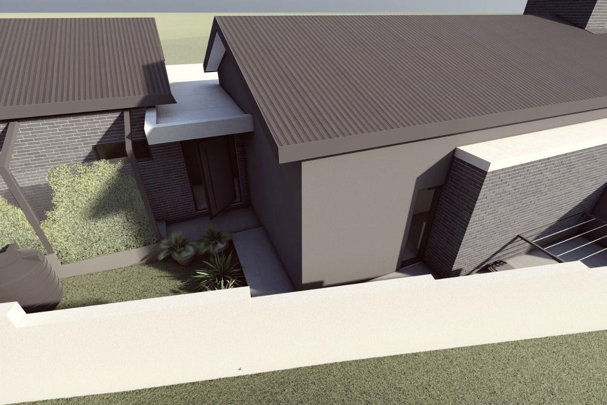 An aerial perspective of a modern residential property featuring a corrugated metal roof, brick exterior walls, and a secure boundary wall.