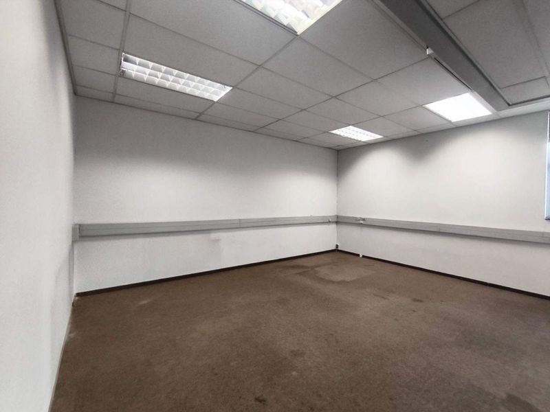 An empty office space featuring a suspended ceiling with recessed lighting and perimeter electrical trunking, suitable for a variety of commercial uses.