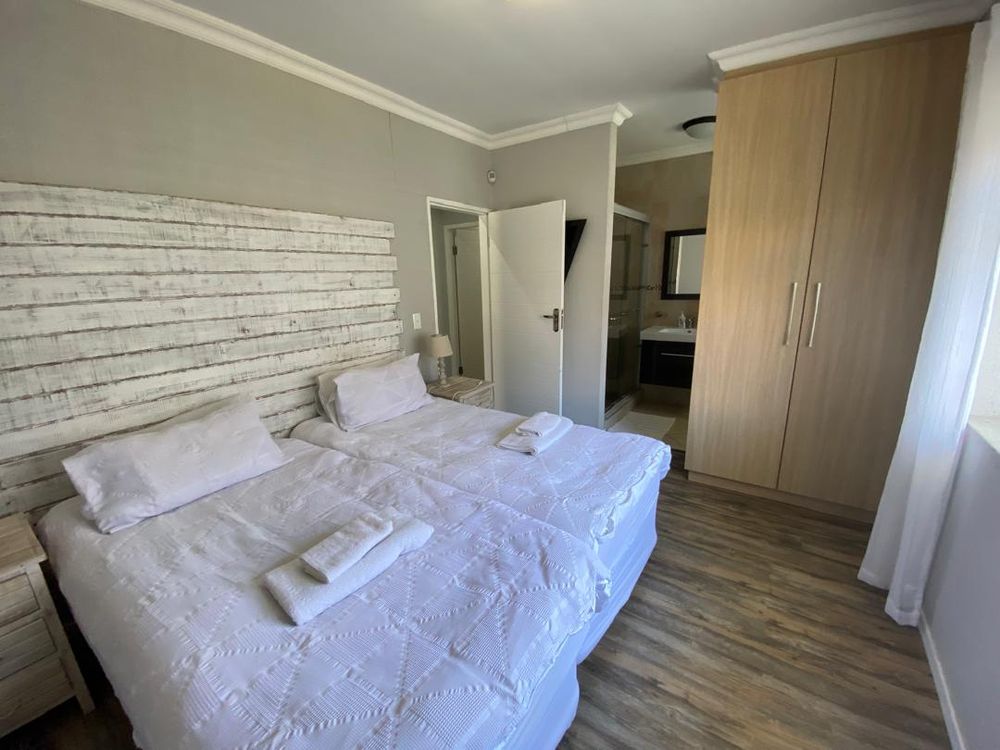 Ground floor, bedroom 2 with built-in cupboards and en-suite bathroom. 