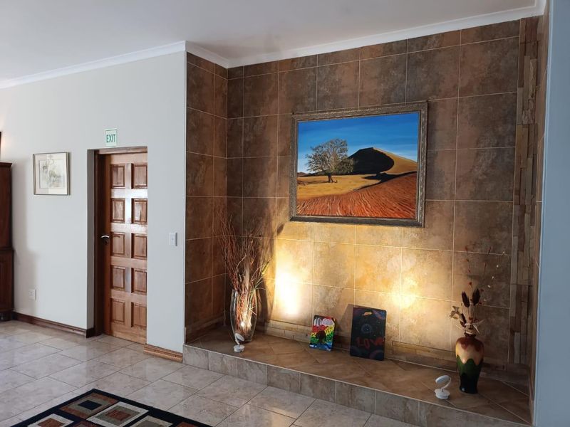 A living area featuring a tiled feature wall with a raised hearth and a solid wooden door.
