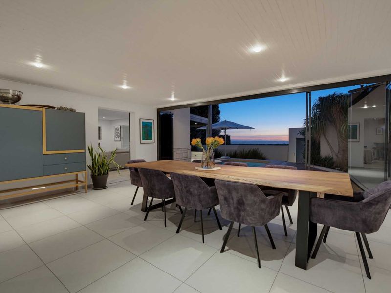 Spacious dining area featuring large sliding glass doors that open to an outdoor patio and pool area, creating a seamless indoor-outdoor flow.