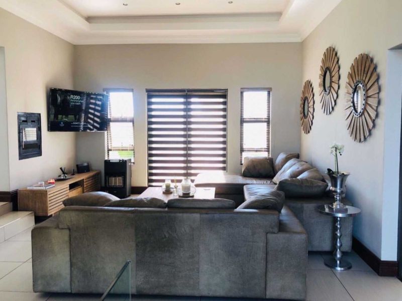 Spacious living room featuring tiled floors, a recessed ceiling, and large sliding glass doors that provide ample natural light.