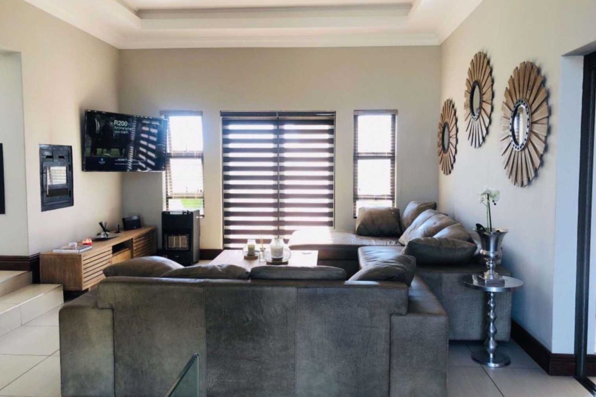 Spacious living room featuring tiled floors, a recessed ceiling, and large sliding glass doors that provide ample natural light.