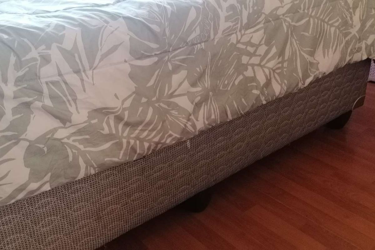 A close-up view of a bedroom featuring laminate flooring.