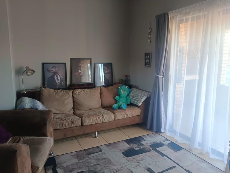 A living room area featuring tiled flooring and a sliding glass door providing access to the exterior.