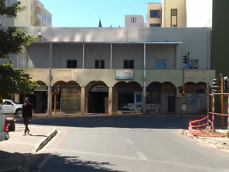 Street-level view of a commercial building facade featuring arched architectural details and signage for a medical practice.