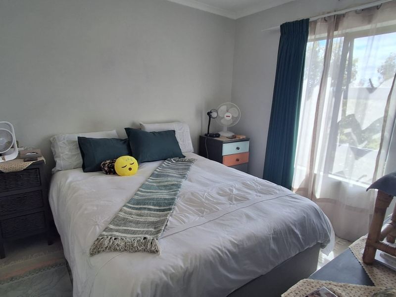 A standard bedroom featuring neutral wall finishes and a window with curtain tracks, providing a functional space for rest.