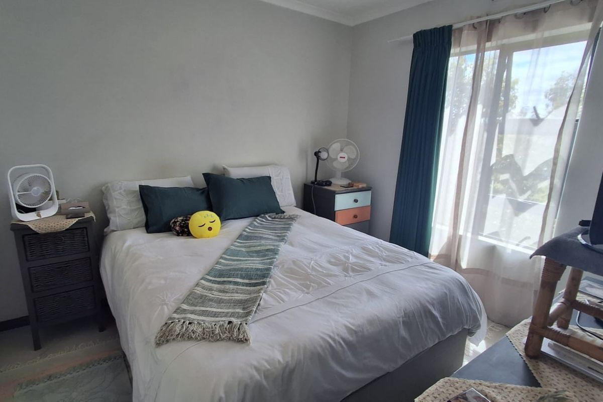 A standard bedroom featuring neutral wall finishes and a window with curtain tracks, providing a functional space for rest.