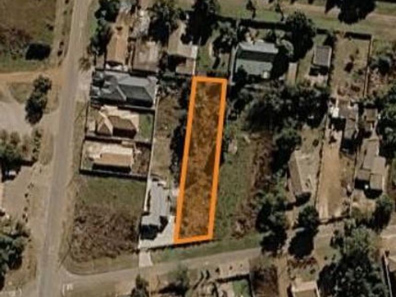 An aerial view of a vacant residential land parcel highlighted in orange, situated within an established suburban neighborhood.