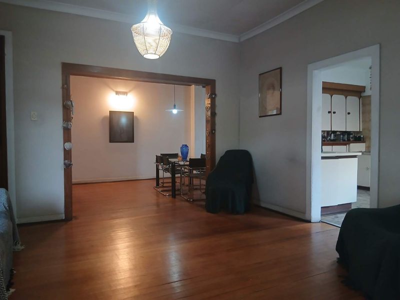 Open plan living and dining area featuring polished hardwood flooring and direct access to a functional kitchen space.