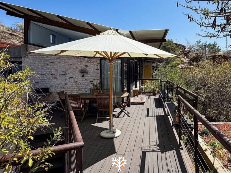 Spacious elevated timber deck featuring a modern skillion roof, exposed brickwork, and metal railings, offering a seamless transition to the outdoor living area.