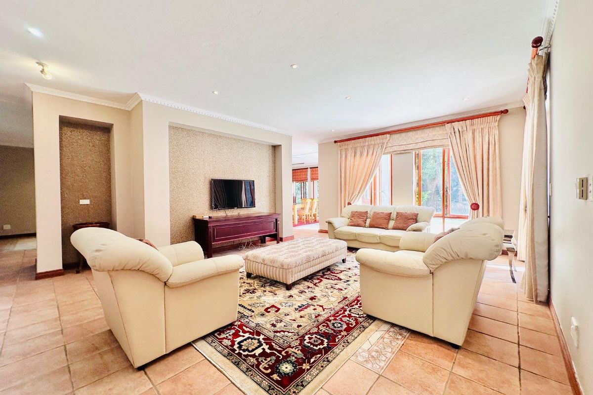Spacious living room featuring tiled flooring, recessed ceiling lighting, and a dedicated media wall alcove with direct access to the dining area.