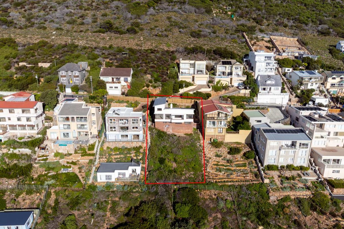 Aerial view of a residential property plot situated on a hillside, highlighting the sloped terrain and surrounding neighborhood context.