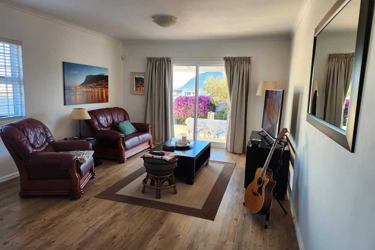 A comfortable living room featuring laminate flooring and a sliding glass door that provides direct access to the outdoor patio area.
